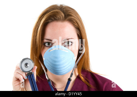 Krankenschwester, Peelings und einen Mundschutz tragen hält ein Stethoskop. Stockfoto