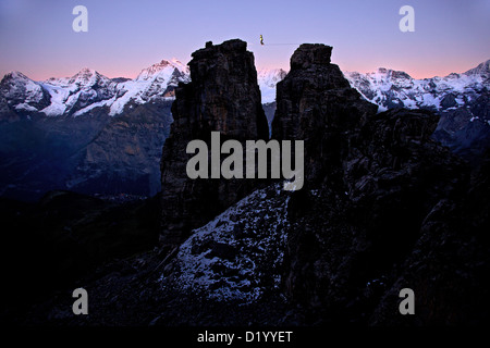 Mann zu Fuß eine Highline zwischen zwei Felsen, Schilthorn, Berner Oberland, Kanton Bern, Schweiz Stockfoto