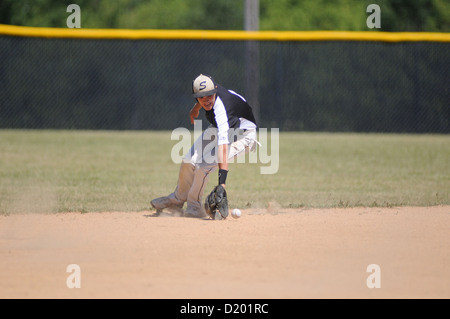 Baseball zweiter Basisspieler fährt hinter die zweite Basis einen Ball High School Spiel die Oberhand. USA. Stockfoto