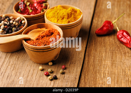 Vier Arten von Gewürzen und einige Jalapenos auf dem Holztisch Stockfoto