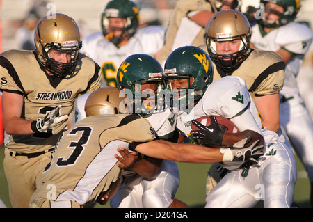 Fußball zurück laufen zusammen mit einem Blocker durch eine Tackler während einer High School Football Spiel angehalten. USA. Stockfoto