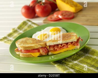 Gegrillter Speck, Käse und Tomaten-Frühstücks-Sandwich mit zwei Eiern sonnigen Seite nach oben Stockfoto