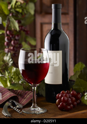 Glas Rotwein mit Flasche Stockfoto