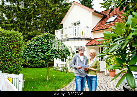 Junges Paar sucht Dokumente vor einem Haus, Hamburg, Germany Stockfoto