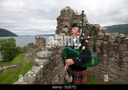 Drumnadrochit, Vereinigtes Königreich, ein Dudelsack-Spieler auf den Ruinen von Urquhart Castle am Loch Ness Stockfoto