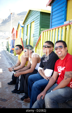 Männer sitzen vor Edwardian Beach Houses, Muizenberg, Halbinsel, Cape Town, Südafrika, Afrika Stockfoto