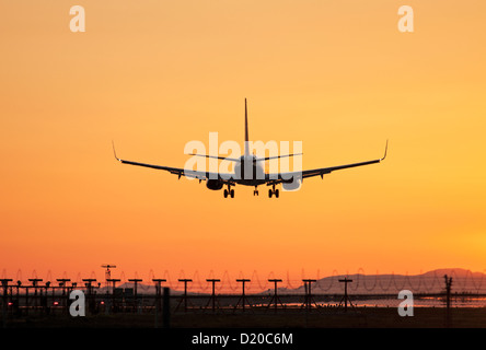 Eine Boeing 737-Jetliner Silhouette gegen einen bunten Himmel bei Sonnenuntergang, Vancouver International Airport, Deutschland Stockfoto
