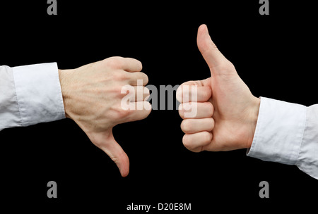 Zwei Hände mit verschiedenen Gesten. Daumen hoch und Daumen nach unten auf schwarzem Hintergrund Stockfoto