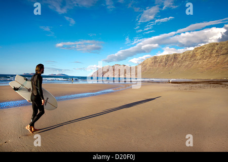 Surfer am Strand Playa de Famara Gebirge Risco de Famara, Lanzarote, Kanarische Inseln, Spanien, Europa Stockfoto