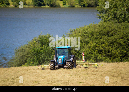 Landwirt mit Traktor verwendet gemähten Getreidefeld, hinter einem Damm, Bad Soden-Salmunster, Hessen, Deutschland, Europa Stockfoto