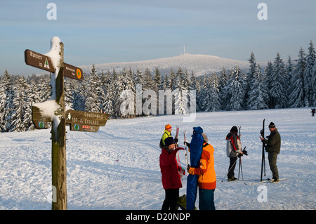 Kreuz, Langläufer, verschneiten Wald, Brocken Berg im Hintergrund, Torfhaus, Altenau, Harz, Niedersachsen, Deutschland Stockfoto