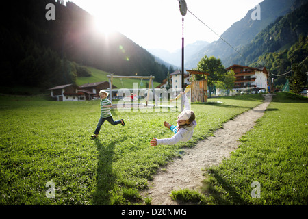 Mädchen spielen auf der Seilrutsche, outdoor-Bereich des Hotel Feuerstein, Pflersch, Gossensaß, Südtirol, Italien Stockfoto
