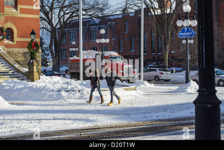 Paare, die auf einer Winter-Straße mit Kopf beugte sich in den Wind. Stockfoto