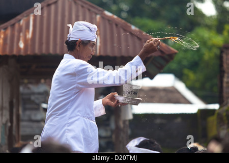 BALI - FEBRUAR 1. Priester Segen Anbeter mit Weihwasser für Galungan Zeremonie am 1. Februar 2012 in Bali, Indonesien. Stockfoto