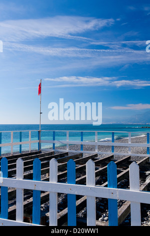 Eine rote Fahne auf einer Hecke an einem Strand Stockfoto
