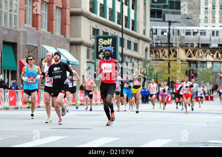 USA Illinois-Chicago 2012 35. Chicago-Marathon Cluster der Läufer laufen unter einem lokalen Wahrzeichen Schleife Struktur und Zug erhöht Stockfoto