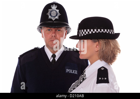 Studioaufnahme von männlichen und weiblichen britischen Polizisten in traditioneller Uniform. Stockfoto