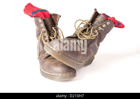 Vintage braune Stiefel mit roten Socken auf weißem Hintergrund Stockfoto