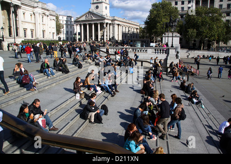 Büroangestellte und Touristen mit Mittagessen auf Schritte vor der National Gallery Trafalgar Square London Stockfoto