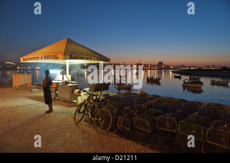 Grill am Arade Fluss in Ferragudo und Aussicht über den Fluss in Richtung Portimao am Abend, Algarve, Portugal, Europa Stockfoto