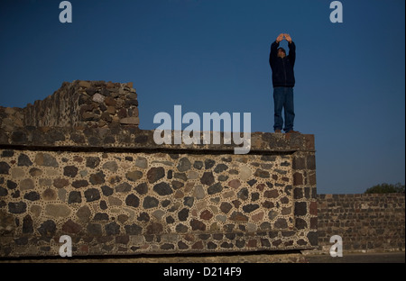 Ein Mann betet auf einem Gebäude entlang der Straße der Toten in der archäologischen Stätte von Teotihuacan, Mexiko Stockfoto