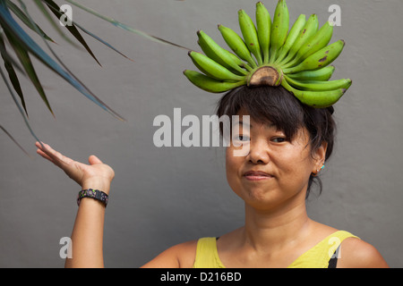 Glückliche und gesunde Frau mit Banane Krone auf dem Kopf Stockfoto