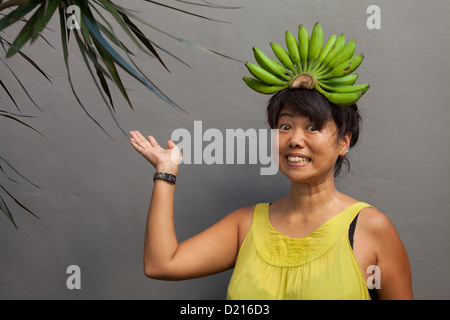 Glückliche und gesunde Frau mit Banane Krone auf dem Kopf Stockfoto