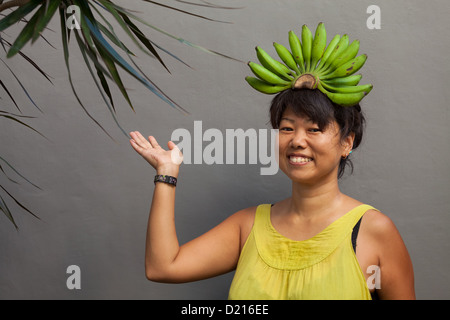 Glückliche und gesunde Frau mit Banane Krone auf dem Kopf Stockfoto