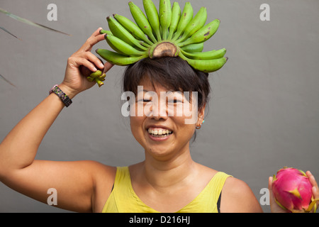 Glückliche und gesunde Frau mit Banane Krone auf dem Kopf Stockfoto