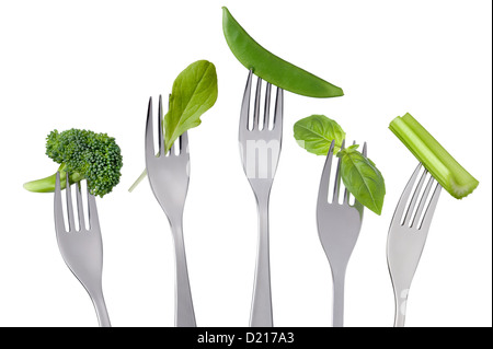 grüne Rohkost auf Gabeln auf weißen Hintergrund isoliert Stockfoto