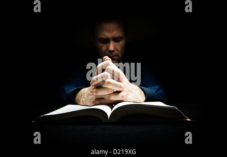 Mann mit seinen Händen ruht auf eine Bibel zu Gott zu beten. Stockfoto