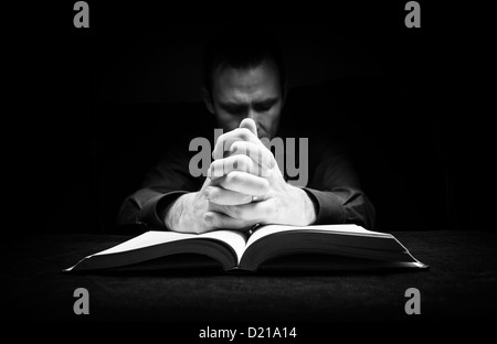 Mann mit seinen Händen ruht auf eine Bibel zu Gott zu beten. Stockfoto