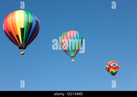 Drei bunte Heißluftballons in einem blauen Himmel schweben Stockfoto