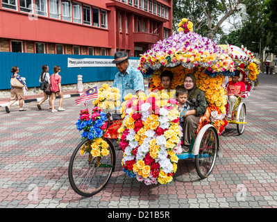 Touristen auf Rikscha-Fahrt in Melaka, Malaysia, sind eine beliebte Touristenattraktion Stockfoto