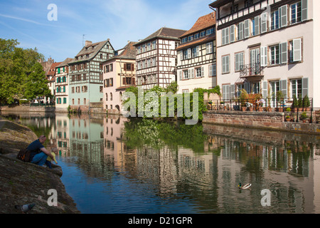 Vater und Tochter füttern Enten Kanal entlang mit Fachwerkhäusern im Viertel La Petite France, Straßburg, Elsass, Frankreich Stockfoto