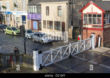 Verkehr und Fußgänger auf der East Lancashire Railway am Ramsbottom Bahnübergang Tore warten. Stockfoto