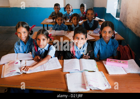 Lächelnden jungen und Mädchen Grundschüler in blauen Uniformen in einem Klassenzimmer einer Grundschule in der Nähe von Udaipur Rajasthan Indien Stockfoto