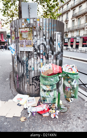 Überquellenden Abfallbehälter durch eine öffentliche Toilette auf einer Stadtstraße - Paris, Frankreich Stockfoto