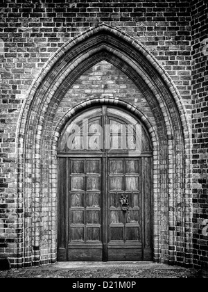 Ein schwarz-weiß Foto von einem Rundbogen zu einer gotischen Kirche. Stockfoto