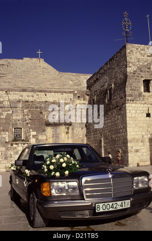 Blumenstrauß aus gemischten Blumen auf Mercedes Auto vor der Kirche der Geburt, oder die Geburtskirche, in der West Bank Town Of Bethlehem in der Autonomen Palästinensischen Autonomiebehörde Israel Stockfoto