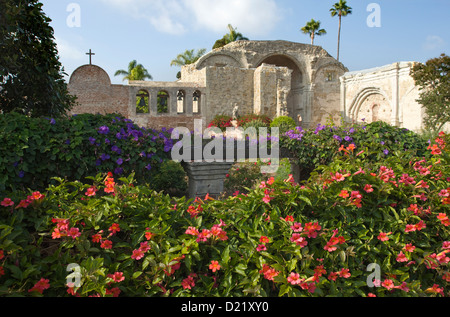 BLUMEN IM GARTEN GROßE STEIN KIRCHENRUINEN MISSION SAN JUAN CAPISTRANO ORANGE COUNTY KALIFORNIEN USA Stockfoto