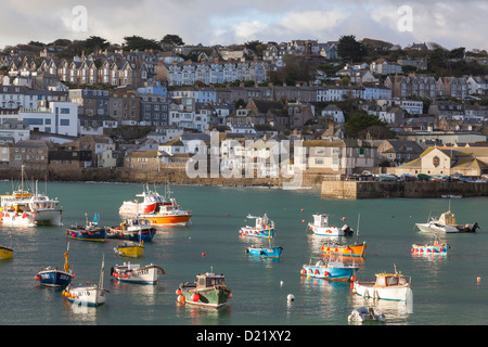 Kleine bunte Fischerboote vertäut im Hafen von St. Ives bei Flut in der Abendsonne Winter. Stockfoto