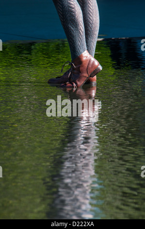 Junge Frau die Füße in braunen Schuhen waten im seichten Wasser Stockfoto