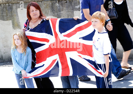 Eine Familie hält der Union Jack-Flagge bei einer militärischen Beerdigung im Vereinigten Königreich. Stockfoto