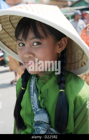 Ein Teilnehmer, mit traditionellen konischen Hut, lächelt während einer Parade der Bauernherbst in Tumpang Dorf, Java, Indonesien Stockfoto