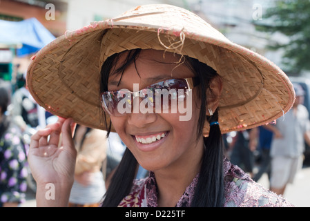 Ein Teilnehmer, mit traditionellen konischen Hut, lächelt während einer Parade der Bauernherbst in Tumpang Dorf, Java, Indonesien Stockfoto