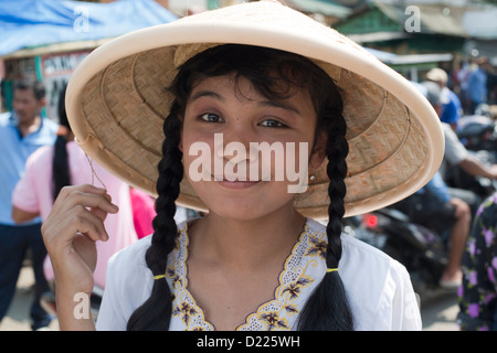 Ein Teilnehmer, mit traditionellen konischen Hut, lächelt während einer Parade der Bauernherbst in Tumpang Dorf, Java, Indonesien Stockfoto