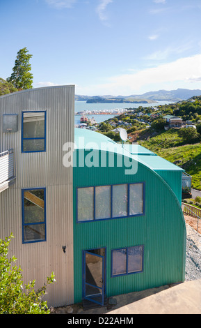 Ein skurriler Stil Wellpappe Metall Haus mit Blick auf Hafen von Lyttleton. Christchurch, Canterbury, Südinsel, Neuseeland. Stockfoto