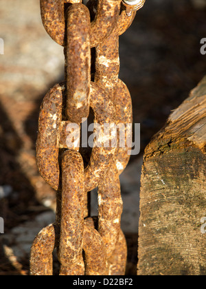 alte rote rostige Kette in der Nähe das Holzbrett Stockfoto