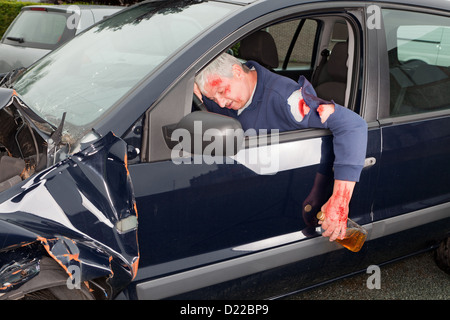 Betrunkenen Autofahrer aus seinem abgestürzten Auto hängen Stockfoto